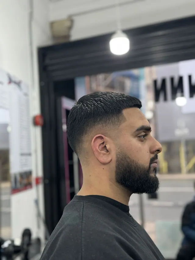 A short textured crop with a fade and a beard