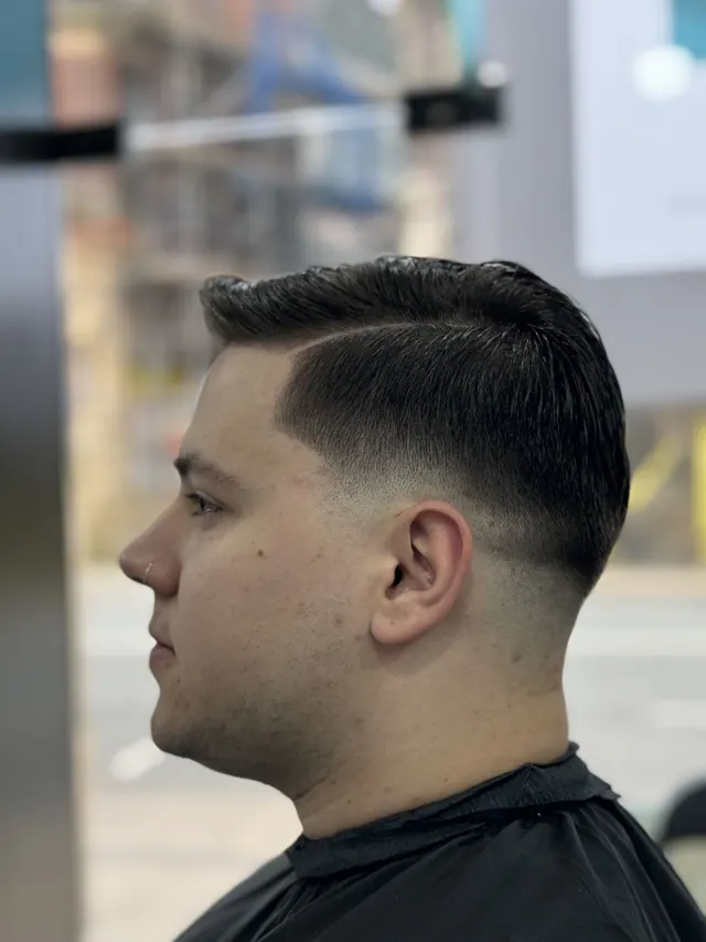 A side-parted cut with a low fade