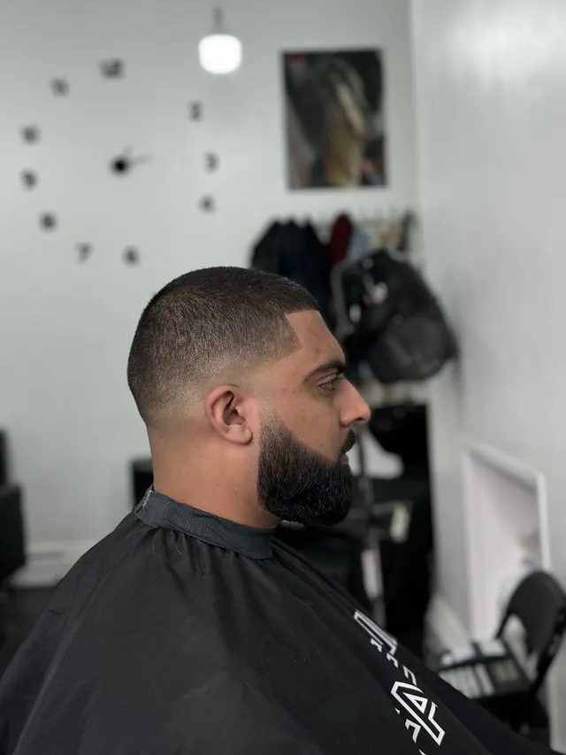 A buzz cut with a fade and a full beard